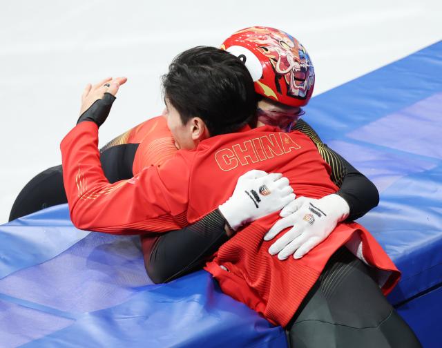 (260212) -- MILAN, Feb. 12, 2026 (Xinhua) -- Sun Long (back) of China celebrates with teammate Liu Shaoang after the short track speed skating men's 1000m final A at the Milan-Cortina 2026 Olympic Winter Games in Milan, Italy, Feb. 12, 2026. (Xinhua/Li Ming)