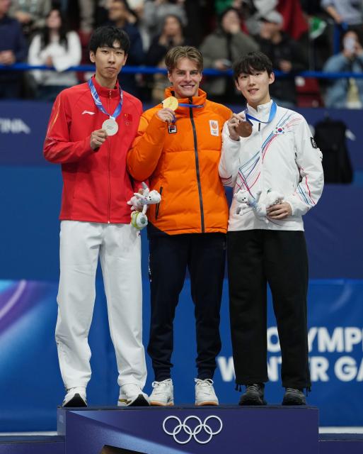(260212) -- MILAN, Feb. 12, 2026 (Xinhua) -- Gold medalist Jens van 'T Wout (C) of the Netherlands, silver medalist Sun Long (L) of China, and bronze medalist RIM Jongun of South Korea pose for a photo during the awarding ceremony of the short track speed skating men's 1000m at the Milan-Cortina 2026 Olympic Winter Games in Milan, Italy, Feb. 12, 2026. (Xinhua/Xue Yuge)