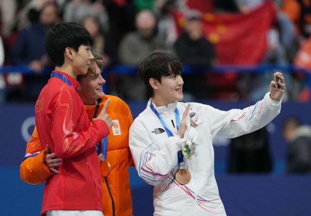 (260212) -- MILAN, Feb. 12, 2026 (Xinhua) -- Gold medalist Jens van 'T Wout (C) of the Netherlands, silver medalist Sun Long (L) of China, and bronze medalist RIM Jongun of South Korea take a selfie during the awarding ceremony of the short track speed skating men's 1000m at the Milan-Cortina 2026 Olympic Winter Games in Milan, Italy, Feb. 12, 2026. (Xinhua/Xue Yuge)