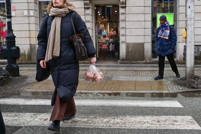 (260212) -- WARSAW, Feb. 12, 2026 (Xinhua) -- A woman carries traditional doughnuts on a street in Warsaw, Poland on Feb. 12, 2026. People in Poland eat traditional doughnuts on Fat Thursday to mark the last Thursday before the start of Lent. (Photo by Aleksy Witwicki/Xinhua)