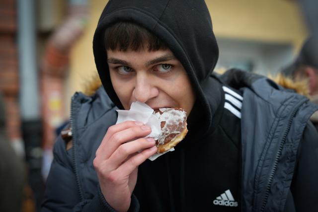(260212) -- WARSAW, Feb. 12, 2026 (Xinhua) -- A man eats a traditional doughnut in Warsaw, Poland on Feb. 12, 2026. People in Poland eat traditional doughnuts on Fat Thursday to mark the last Thursday before the start of Lent. (Photo by Jaap Arriens/Xinhua)