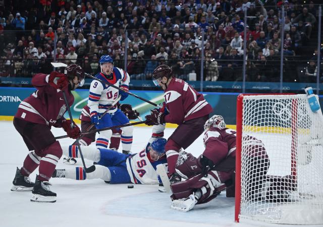 (260213) -- MILAN, Feb. 13, 2026 (Xinhua) -- Players of both teams compete during the ice hockey men's preliminary round group C match between the United States and Latvia at the Milan-Cortina 2026 Olympic Winter Games in Milan, Italy, Feb. 12, 2026. (Xinhua/Zhang Haofu)