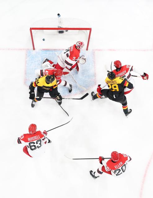 (260213) -- MILAN, Feb. 13, 2026 (Xinhua) -- Players of both teams compete during the ice hockey men's preliminary round group C match between Denmark and Germany at the Milan-Cortina 2026 Olympic Winter Games in Milan, Italy, Feb. 12, 2026. (Xinhua/Wang Kaiyan)