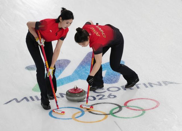 (260213) -- CORTINA D'AMPEZZO, Feb. 13, 2026 (Xinhua) -- Dong Ziqi (R) of China and her teammate Jiang Jiayi compete during the curling women round robin session 2 match between China and Britain at the 2026 Milan-Cortina Winter Olympics in Cortina D'Ampezzo, Italy, Feb. 12, 2026. (Xinhua/Li Gang)