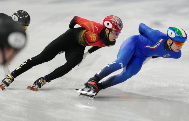(260213) -- MILAN, Feb. 13, 2026 (Xinhua) -- Sun Long (L) of China competes during the short track speed skating men's 1000m quarterfinal at the Milan-Cortina 2026 Olympic Winter Games in Milan, Italy, Feb. 12, 2026. (Xinhua/Xue Yuge)