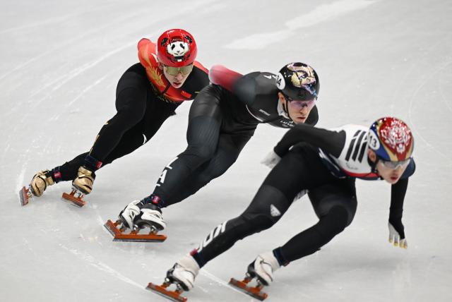 (260213) -- MILAN, Feb. 13, 2026 (Xinhua) -- Lin Xiaojun (L) of China competes during the short track speed skating men's 1000m quarterfinal at the Milan-Cortina 2026 Olympic Winter Games in Milan, Italy, Feb. 12, 2026. (Xinhua/Cheng Min)
