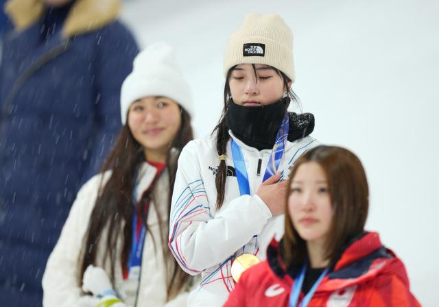 (260213) -- LIVIGNO, Feb. 13, 2026 (Xinhua) -- Choi Gaon (C) of South Korea reacts during the awarding ceremony of the women's snowboard halfpipe final at the Milan-Cortina 2026 Olympic Winter Games in Livigno, Italy, Feb. 12, 2026. (Xinhua/Xia Yifang)