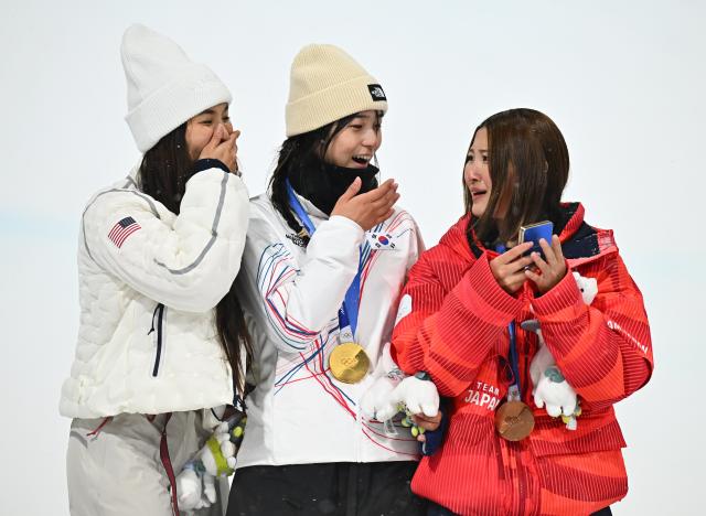 (260213) -- LIVIGNO, Feb. 13, 2026 (Xinhua) -- Gold medalist Choi Gaon (C) of South Korea, silver medalist Chloe Kim (L) of the United States and bronze medalist Ono Mitsuki of Japan react on the podium after the women's snowboard halfpipe final at the Milan-Cortina 2026 Olympic Winter Games in Livigno, Italy, Feb. 12, 2026. (Xinhua/Zhang Hongxiang)
