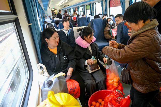 (260213) -- TONGREN, Feb. 13, 2026 (Xinhua) -- A villager (R) from Hunan Province sells fruits to passengers on the train No. 7272 on Feb. 12, 2026.
  The train No. 7272/7271 has run across the mountainous areas in Hunan, Guizhou and Chongqing for almost 20 years. With an average speed of just 40 kilometers per hour, the train has made it easier for residents along the route to travel and commute, while also helping local products reach wider markets. (Xinhua/Liu Xu)