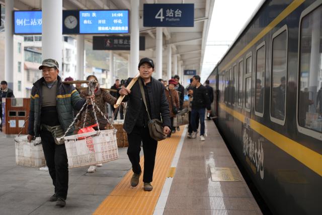 (260213) -- TONGREN, Feb. 13, 2026 (Xinhua) -- Villagers from Hunan Province carrying empty baskets after selling their goods prepare to board the train No. 7271 at the Tongren Railway Station in Tongren City, southwest China's Guizhou Province, Feb. 12, 2026.
  The train No. 7272/7271 has run across the mountainous areas in Hunan, Guizhou and Chongqing for almost 20 years. With an average speed of just 40 kilometers per hour, the train has made it easier for residents along the route to travel and commute, while also helping local products reach wider markets. (Xinhua/Liu Xu)