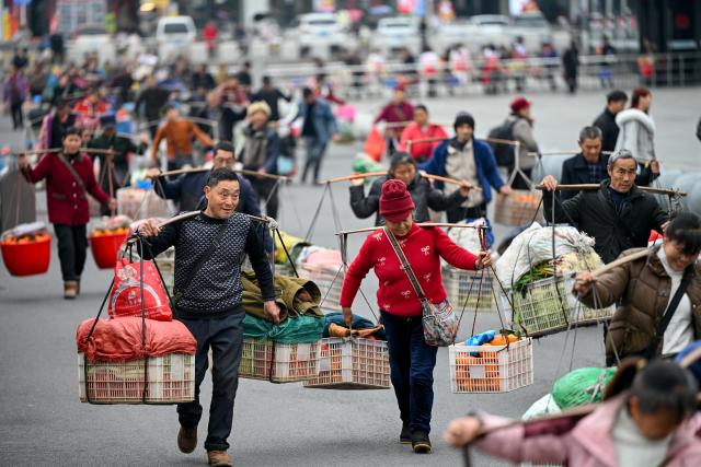(260213) -- TONGREN, Feb. 13, 2026 (Xinhua) -- Farmers from Hunan Province carrying goods for sale walk to a market in Tongren City, southwest China's Guizhou Province, Feb. 12, 2026.
  The train No. 7272/7271 has run across the mountainous areas in Hunan, Guizhou and Chongqing for almost 20 years. With an average speed of just 40 kilometers per hour, the train has made it easier for residents along the route to travel and commute, while also helping local products reach wider markets. (Photo by Yuan Fuhong/Xinhua)