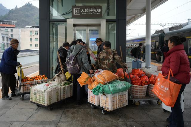 (260213) -- TONGREN, Feb. 13, 2026 (Xinhua) -- Villagers from Hunan Province carrying goods for sale prepare to leave the Tongren Railway Station in Tongren City, southwest China's Guizhou Province, Feb. 12, 2026.
  The train No. 7272/7271 has run across the mountainous areas in Hunan, Guizhou and Chongqing for almost 20 years. With an average speed of just 40 kilometers per hour, the train has made it easier for residents along the route to travel and commute, while also helping local products reach wider markets. (Photo by Long Jianrui/Xinhua)