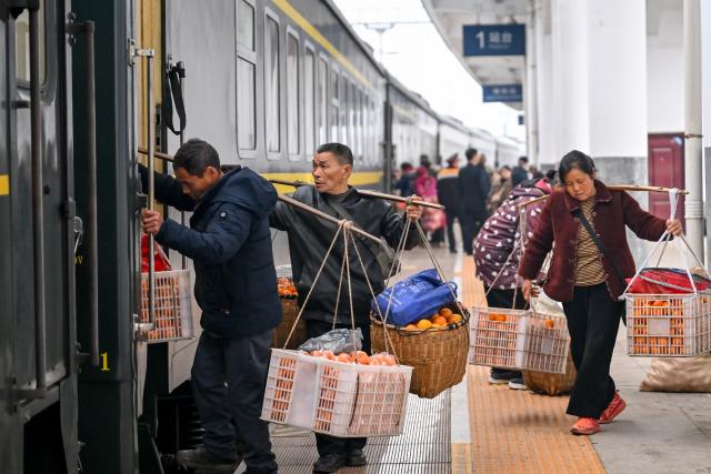 (260213) -- TONGREN, Feb. 13, 2026 (Xinhua) -- Farmers carrying goods for sale board the train No. 7272 at Jinhe Railway Station in central China's Hunan Province, Feb. 12, 2026.
  The train No. 7272/7271 has run across the mountainous areas in Hunan, Guizhou and Chongqing for almost 20 years. With an average speed of just 40 kilometers per hour, the train has made it easier for residents along the route to travel and commute, while also helping local products reach wider markets. (Photo by Yuan Fuhong/Xinhua)