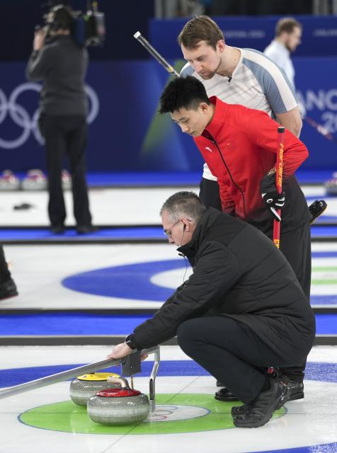 (260213) -- CORTINA D'AMPEZZO, Feb. 13, 2026 (Xinhua) -- Fei Xueqing (C) of China and Gaute Nepstad (back) of Norway watch as the referee measures distance during the curling men round robin session 3 match between China and Norway at the Milan-Cortina 2026 Olympic Winter Games in Cortina, Italy, Feb. 13, 2026. (Xinhua/Li Gang)