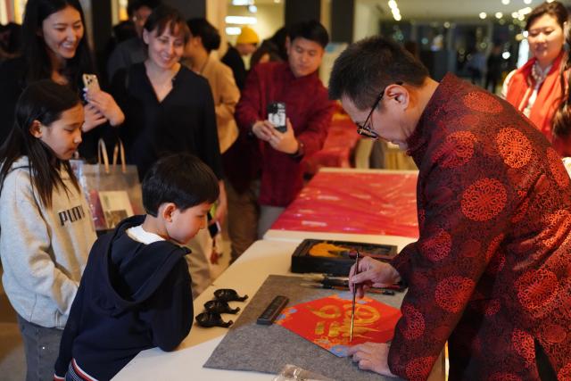 (260213) -- NEW YORK, Feb. 13, 2026 (Xinhua) -- People watch a display of Chinese calligraphy at a Chinese New Year gala at the UN headquarters in New York, on Feb. 12, 2026. (Xinhua/Zhang Fengguo)