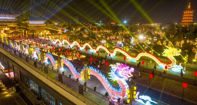 (260213) -- BEIJING, Feb. 13, 2026 (Xinhua) -- This aerial drone photo taken on Feb. 12, 2026 shows tourists viewing lanterns and lighting installations at a scenic area in Luoyang, central China's Henan Province. Various festive events are held across China to celebrate the upcoming Chinese New Year of the Horse. (Photo by Zhang Yixi/Xinhua)