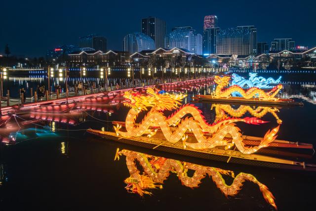 (260213) -- BEIJING, Feb. 13, 2026 (Xinhua) -- This aerial drone photo taken on Feb. 12, 2026 shows lanterns lighting installations on the Wujiang River in Jinhua, east China's Zhejiang Province. Various festive events are held across China to celebrate the upcoming Chinese New Year of the Horse. (Photo by Lou Jiyang/Xinhua)