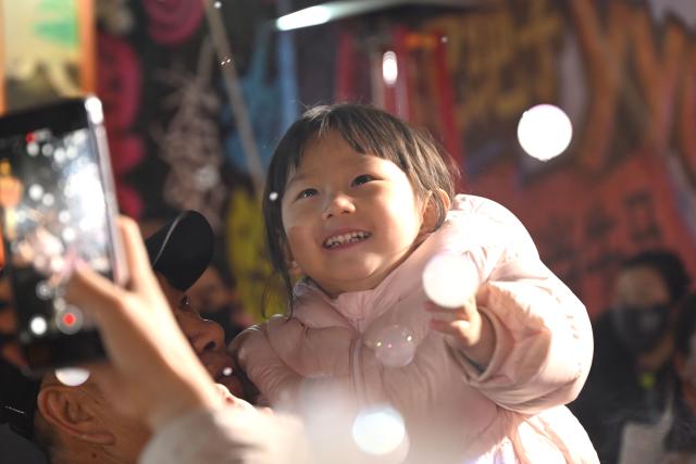 (260213) -- BEIJING, Feb. 13, 2026 (Xinhua) -- A girl has fun at a night market in Dunhuang, northwest China's Gansu Province, Feb. 12, 2026. Various festive events are held across China to celebrate the upcoming Chinese New Year of the Horse. (Photo by Zhang Xiaoliang/Xinhua)