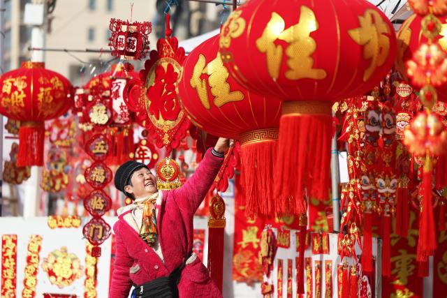 (260213) -- BEIJING, Feb. 13, 2026 (Xinhua) -- A shop owner arranges Chinese New Year decorations at a market in Tancheng County of Linyi City, east China's Shandong Province, Feb. 13, 2026. Markets across the country are bustling nowadays as people flock there to stock up on goods in preparation for the upcoming Spring Festival, or the Chinese New Year. (Photo by Zhang Chunlei/Xinhua)