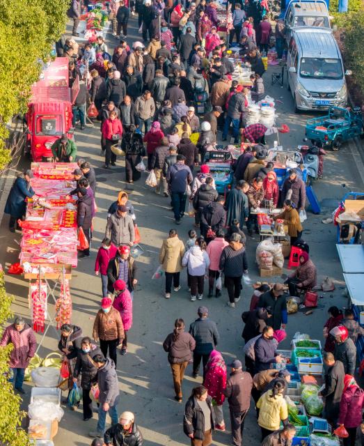 (260213) -- BEIJING, Feb. 13, 2026 (Xinhua) -- This aerial drone photo shows people purchasing goods needed for the Chinese New Year celebrations at a market in Yinji Township of Huai'an City, east China's Jiangsu Province, Feb. 13, 2026. Markets across the country are bustling nowadays as people flock there to stock up on goods in preparation for the upcoming Spring Festival, or the Chinese New Year. (Photo by Yang Yugang/Xinhua)