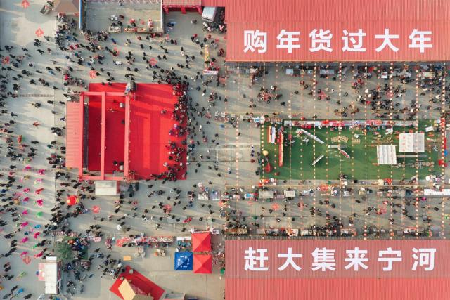 (260213) -- BEIJING, Feb. 13, 2026 (Xinhua) -- This aerial drone photo shows people purchasing goods needed for the Chinese New Year celebrations at a market in north China's Tianjin, Feb. 10, 2026. Markets across the country are bustling nowadays as people flock there to stock up on goods in preparation for the upcoming Spring Festival, or the Chinese New Year. (Photo by Du Penghui/Xinhua)