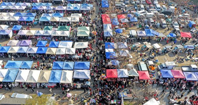 (260213) -- BEIJING, Feb. 13, 2026 (Xinhua) -- This aerial drone photo shows people purchasing goods needed for the Chinese New Year celebrations at a market in Xianju County of Taizhou City, east China's Zhejiang Province, Feb. 11, 2026. Markets across the country are bustling nowadays as people flock there to stock up on goods in preparation for the upcoming Spring Festival, or the Chinese New Year. (Photo by Wang Huabin/Xinhua)