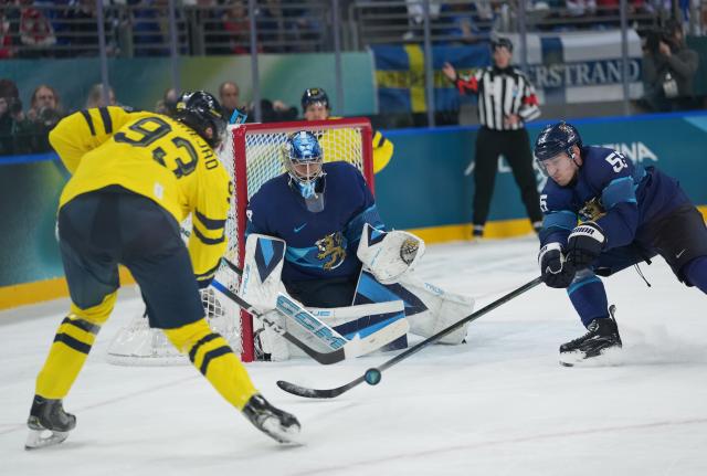 (260213) -- MILAN, Feb. 13, 2026 (Xinhua) -- Mika Zibanejad (L) of Sweden shoots during the ice hockey men's preliminary round group B match between Finland and Sweden at the Milan-Cortina 2026 Olympic Winter Games in Milan, Italy, Feb. 13, 2026. (Xinhua/Tao Xiyi)