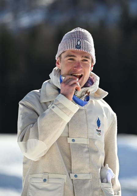 (260213) -- TESERO, Feb. 13, 2026 (Xinhua) -- Silver medalist Mathis Desloges of France bites the medal during the awarding ceremony for the Cross-Country Skiing Men's 10km Interval Start Free at the Milano Cortina 2026 Olympic Winter Games in Tesero, Italy, Feb. 13, 2026. (Xinhua/He Canling)