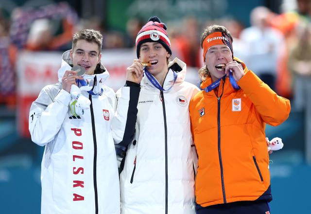 (260213) -- MILAN, Feb. 13, 2026 (Xinhua) -- Gold medalist Metodej Jilek (C) of the Czech Republic, silver medalist Vladimir Semirunniy (L) of Poland and bronze medalist Jorrit Bergsma of the Netherlands bite their medals during the awarding ceremony of the speed skating men's 10000m event at the Milan-Cortina 2026 Olympic Winter Games in Milan, Italy, Feb. 13, 2026. (Xinhua/Li Jing)