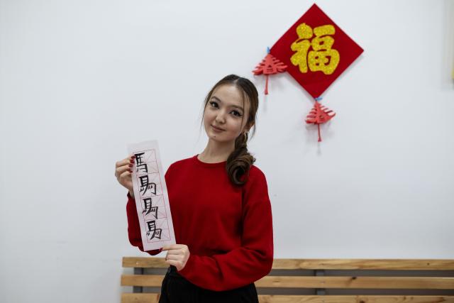 (260213) -- ALMATY, Feb. 13, 2026 (Xinhua) -- A student from the Confucius Institute at Al-Farabi Kazakh National University displays her Chinese calligraphy during a Chinese New Year cultural event in Almaty, Kazakhstan, Feb. 13, 2026. (Xinhua/Li Renzi)