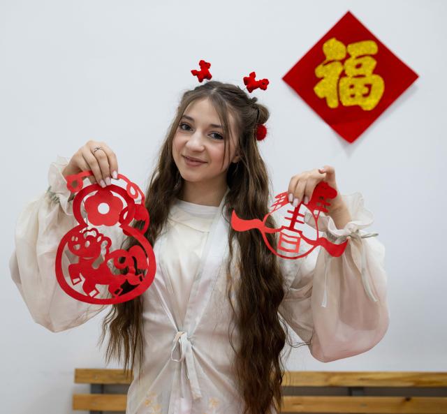 (260213) -- ALMATY, Feb. 13, 2026 (Xinhua) -- A student from the Confucius Institute at Al-Farabi Kazakh National University displays her paper-cutting works during a Chinese New Year cultural event in Almaty, Kazakhstan, Feb. 13, 2026. (Xinhua/Li Renzi)