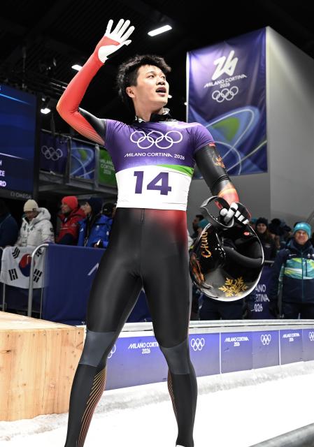 (260213) -- CORTINA D'AMPEZZO, Feb. 13, 2026 (Xinhua) -- Lin Qinwei of China waves after the skeleton men competition at the Milan-Cortina 2026 Olympic Winter Games in Cortina, Italy, Feb. 13, 2026. (Xinhua/Lian Yi)