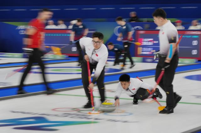 (260213) -- CORTINA D'AMPEZZO, Feb. 13, 2026 (Xinhua) -- Fei Xueqing (C) of China competes during the curling men round robin session 4 match between China and Switzerland at the 2026 Milan-Cortina Winter Olympics in Cortina, Italy, Feb. 13, 2026. (Xinhua/Li Gang)