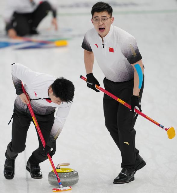 (260213) -- CORTINA D'AMPEZZO, Feb. 13, 2026 (Xinhua) -- Fei Xueqing (L) and Xu Jingtao of China compete during the curling men round robin session 4 match between China and Switzerland at the 2026 Milan-Cortina Winter Olympics in Cortina, Italy, Feb. 13, 2026. (Xinhua/Li Gang)