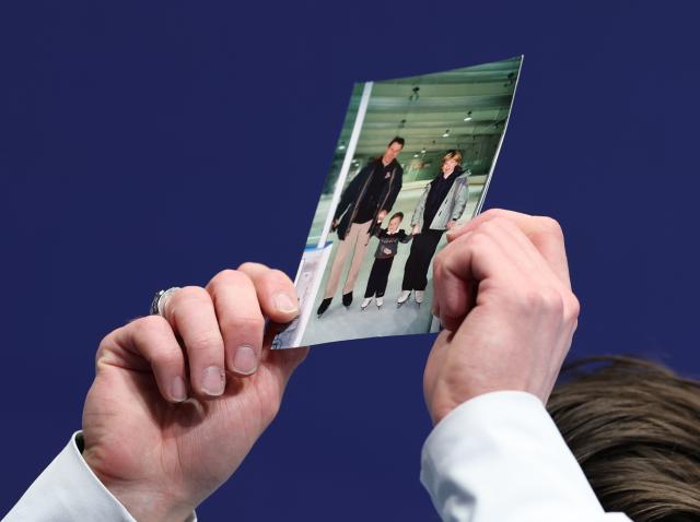 (260213) -- MILAN, Feb. 13, 2026 (Xinhua) -- Maxim Naumov of the United States shows a photo of his parents, who were killed in a plane crash last year, after the free skating of the men single skating match for figure skating event at the Milan-Cortina 2026 Olympic Winter Games in Milan, Italy, Feb. 13, 2026. (Xinhua/Li Ming)