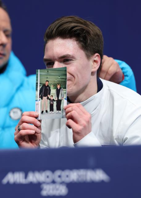 (260213) -- MILAN, Feb. 13, 2026 (Xinhua) -- Maxim Naumov of the United States shows a photo of his parents, who were killed in a plane crash last year, after the free skating of the men single skating match for figure skating event at the Milan-Cortina 2026 Olympic Winter Games in Milan, Italy, Feb. 13, 2026. (Xinhua/Li Ming)