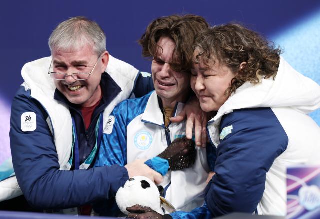 (260214) -- MILAN, Feb. 14, 2026 (Xinhua) -- Mikhail Shaidorov (C) of Kazakhstan reacts as he waits for the score during the men's single skating free skating of figure skating event at the Milan-Cortina 2026 Olympic Winter Games in Milan, Italy, Feb. 13, 2026. (Xinhua/Li Ming)