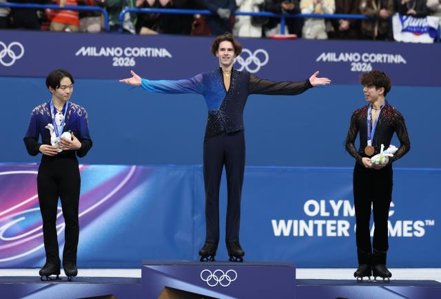 (260214) -- MILAN, Feb. 14, 2026 (Xinhua) -- Gold medalist Mikhail Shaidorov (C) of Kazakhstan celebrates on the podium after the men's single skating free skating of figure skating event at the Milan-Cortina 2026 Olympic Winter Games in Milan, Italy, Feb. 13, 2026. (Xinhua/Li Ming)