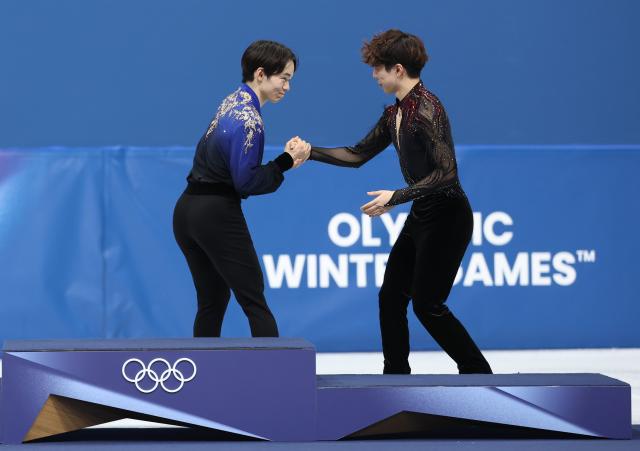 (260214) -- MILAN, Feb. 14, 2026 (Xinhua) -- Silver medalist Kagiyama Yuma (L) of Japan shakes hands with bronze medalist Sato Shun of Japan during the awarding ceremony for the men's single skating free skating of figure skating event at the Milan-Cortina 2026 Olympic Winter Games in Milan, Italy, Feb. 13, 2026. (Xinhua/Li Ming)