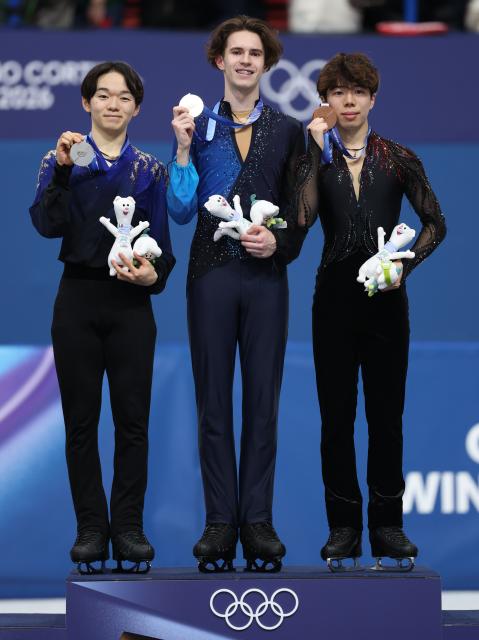 (260214) -- MILAN, Feb. 14, 2026 (Xinhua) -- Silver medalist Kagiyama Yuma of Japan, gold medalist Mikhail Shaidorov of Kazakhstan and bronze medalist Sato Shun of Japan (L to R) pose on the podium after the men's single skating free skating of figure skating event at the Milan-Cortina 2026 Olympic Winter Games in Milan, Italy, Feb. 13, 2026. (Xinhua/Li Ming)