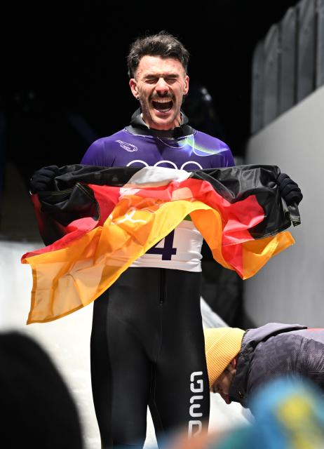 (260214) -- CORTINA D'AMPEZZO, Feb. 14, 2026 (Xinhua) -- Axel Fungk of Germany celebates after his competition during the skeleton men competition heat 4 at the Milan-Cortina 2026 Olympic Winter Games in Cortina, Italy, Feb. 13, 2026. (Xinhua/Lian Yi)