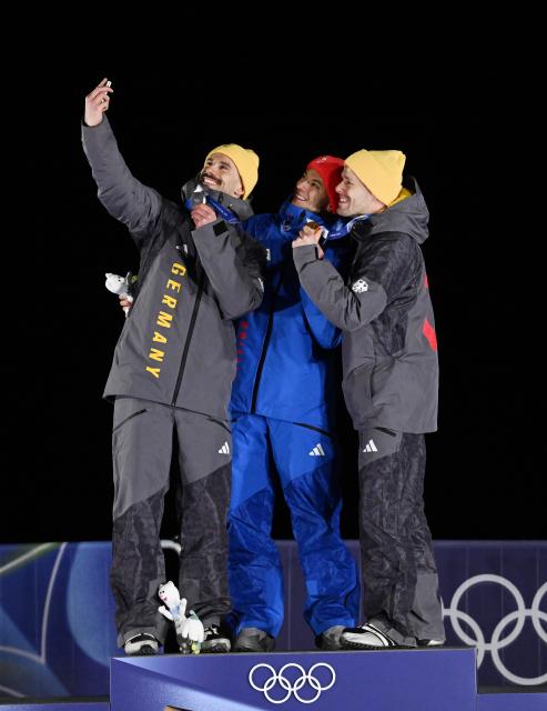 (260214) -- CORTINA D'AMPEZZO, Feb. 14, 2026 (Xinhua) -- Gold medallist Matt Weston (C) of Britain, silver medallist Axel Jungk (L) of Germany and bronze medallist Christopher Grotheer of Germany pose on the podium after the skeleton men's competition at the Milan-Cortina 2026 Olympic Winter Games in Cortina, Italy, Feb. 13, 2026. (Xinhua/Lian Yi)