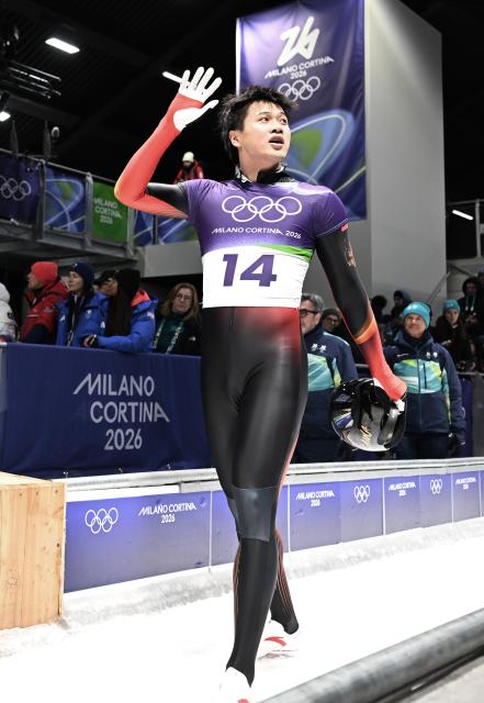 (260214) -- CORTINA D'AMPEZZO, Feb. 14, 2026 (Xinhua) -- China's Lin Qinwei reacts after his competition during the skeleton men competition heat 4 at the Milan-Cortina 2026 Olympic Winter Games in Cortina, Italy, Feb. 13, 2026. (Xinhua/Lian Yi)