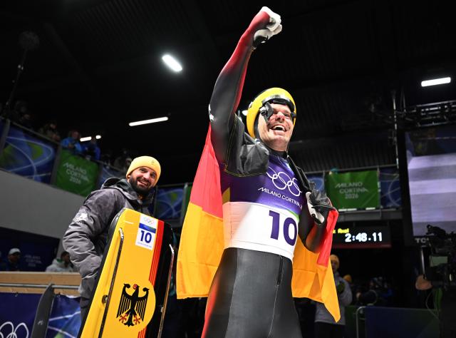 (260214) -- CORTINA D'AMPEZZO, Feb. 14, 2026 (Xinhua) -- Christopher Grotheer (R) celebrates after his competition during the skeleton men competition heat 4 at the Milan-Cortina 2026 Olympic Winter Games in Cortina, Italy, Feb. 13, 2026. (Xinhua/Lian Yi)