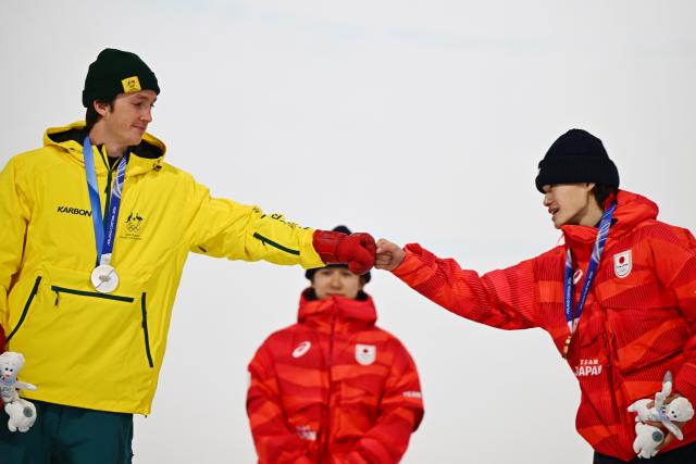 (260214) -- LIVIGNO, Feb. 14, 2026 (Xinhua) -- Silver medalist Scotty James (L) of Australia and bronze medalist Yamada Ryusei (R) of Japan great each other during the awarding ceremony of the men's snowboard halfpipe at the Milan-Cortina 2026 Olympic Winter Games in Livigno, Italy, Feb. 13, 2026. (Xinhua/Zhang Hongxiang)