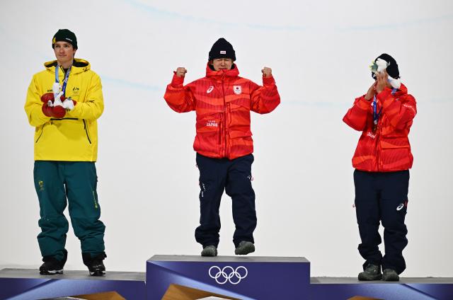 (260214) -- LIVIGNO, Feb. 14, 2026 (Xinhua) -- Gold medalist Totsuka Yuto (C) of Japan, silver medalist Scotty James (L) of Australia and bronze medalist Yamada Ryusei of Japan react during the awarding ceremony of the men's snowboard halfpipe at the Milan-Cortina 2026 Olympic Winter Games in Livigno, Italy, Feb. 13, 2026. (Xinhua/Zhang Hongxiang)