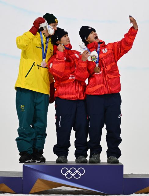 (260214) -- LIVIGNO, Feb. 14, 2026 (Xinhua) -- Gold medalist Totsuka Yuto (C) of Japan, silver medalist Scotty James (L) of Australia and bronze medalist Yamada Ryusei of Japan take selfies during the awarding ceremony of the men's snowboard halfpipe at the Milan-Cortina 2026 Olympic Winter Games in Livigno, Italy, Feb. 13, 2026. (Xinhua/Zhang Hongxiang)