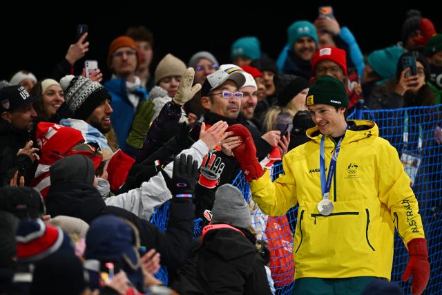 (260214) -- LIVIGNO, Feb. 14, 2026 (Xinhua) -- Silver medalist Scotty James of Australia interacts with spectators during the awarding ceremony of the men's snowboard halfpipe at the Milan-Cortina 2026 Olympic Winter Games in Livigno, Italy, Feb. 13, 2026. (Xinhua/Zhang Hongxiang)