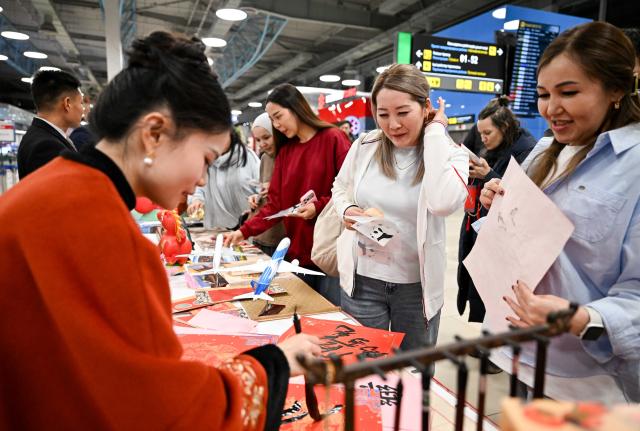 (260214) -- ALMATY, Feb. 14, 2026 (Xinhua) -- Passengers take part in a Chinese New Year cultural event at the Almaty International Airport in Almaty, Kazakhstan, Feb. 13, 2026. (Xinhua/Li Renzi)