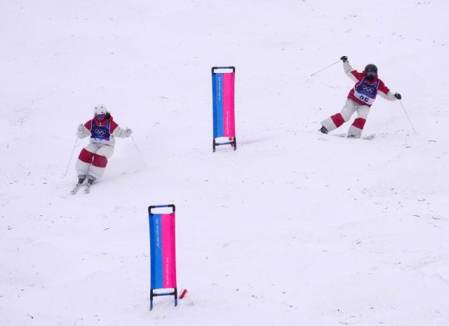 (260214) -- LIVIGNO, Feb. 14, 2026 (Xinhua) -- Li Ruilin (R) of China and Ashley Koehler of Canada compete during the freestyle skiing women's dual moguls 1/16 finals at the Milan-Cortina 2026 Olympic Winter Games in Livigno, Italy, Feb. 14, 2026. (Xinhua/Hu Chao)